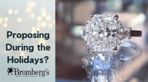 A diamond engagement ring is in sharp focus in the foreground, with a blurred background of twinkling lights. The text reads, "Proposing During the Holidays?" The logo at the bottom says, "Bromberg's - Alabama’s Leading Jeweler Since 1836".