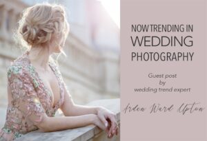 A woman with blonde hair in an updo wearing a floral embroidered dress leaning on a stone railing. The text overlay reads, "Now Trending in Wedding Photography. Guest post by wedding trend expert Arden Ward Upton.