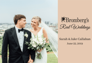 A bride and groom, dressed formally in wedding attire, smile and hold hands while the bride holds a bouquet. The background includes a cityscape and greenery. The right side of the image features text: "Bromberg's Real Weddings, Sarah & Jake Callahan, June 22, 2019.