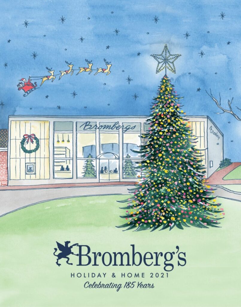 Illustration of a store with "Bromberg's" signage, decorated for the holidays. A large Christmas tree with colorful lights stands prominently in front. Santa and his reindeer fly across a starry sky above. Text reads "Bromberg's Holiday & Home 2021 Celebrating 185 Years.