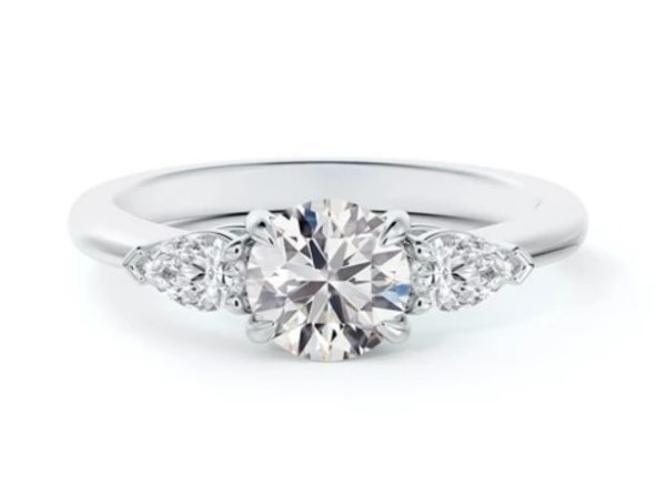 platinum engagement ring with a brilliant cut diamond center accented by two pear-shaped diamonds on each side