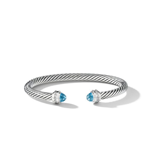 A silver twisted cable bracelet with open ends, each end adorned with a blue gemstone set in a decorative silver setting. The bracelet casts a shadow on a plain white background.