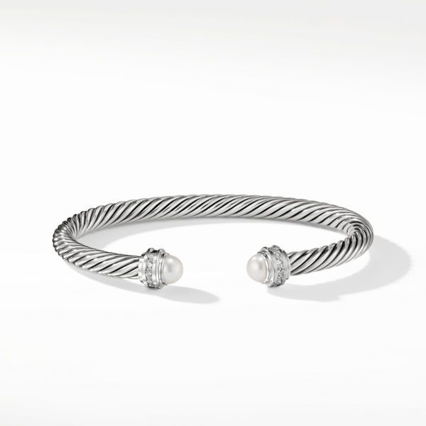 A silver twisted cable bracelet with open ends, each adorned with a round white pearl and silver embellishments. The design is simple yet elegant, set against a plain white background.