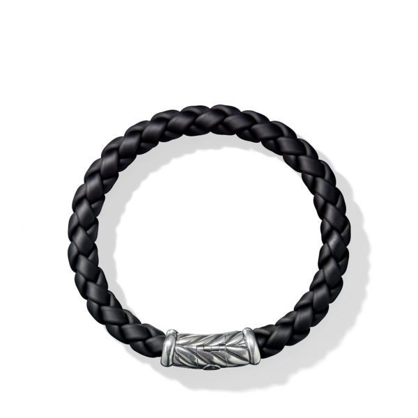 A black braided leather bracelet with a silver clasp featuring intricate engraved patterns. The clasp is cylindrical, adding a touch of elegance to the simple, yet stylish design. The bracelet is arranged in a circular shape on a plain white background.