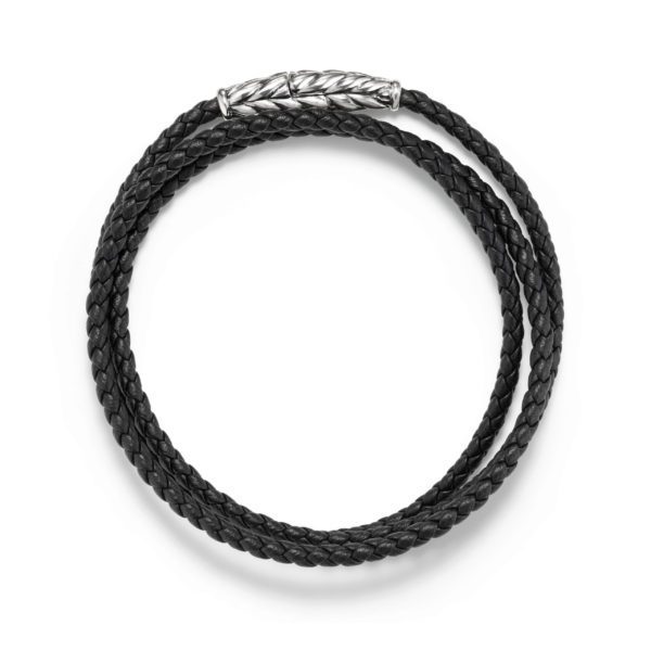 A black braided leather bracelet, coiled into a circular shape, featuring a silver twist clasp. The bracelet is simple yet stylish, suitable for both casual and formal wear.