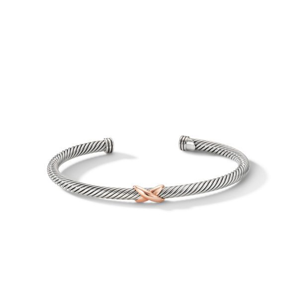 A silver twisted wire bangle with an open cuff design. It features a single rose gold "X" accent in the center. The bangle is displayed against a white background.