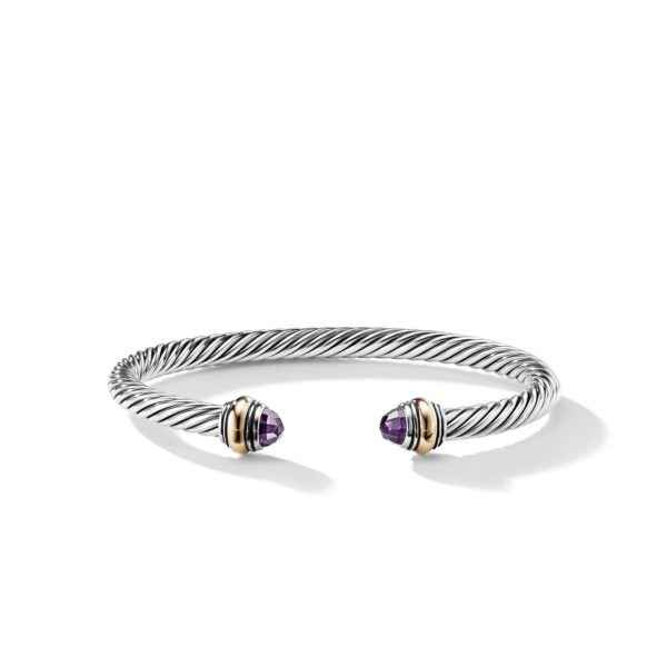 A silver twisted cable cuff bracelet with gold and purple gemstone accents at the open ends. The bracelet has a polished and elegant finish.