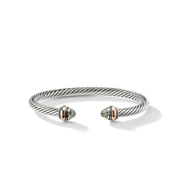 A twisted silver open cuff bracelet with gold accents and green gemstone caps at each end, displayed on a plain white background. The bracelet has a sleek, modern design with a timeless elegance.