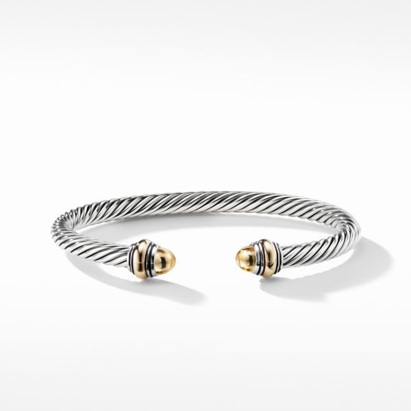 A silver twisted cable bracelet with open ends, each adorned with a smooth, rounded gold cap. The polished gold ends add an elegant contrast to the textured silver braid, giving the bracelet a classic and sophisticated appearance. The background is white.