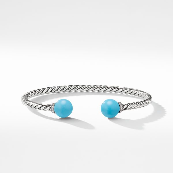 A silver twisted rope-style cuff bracelet featuring two turquoise bead end-caps.