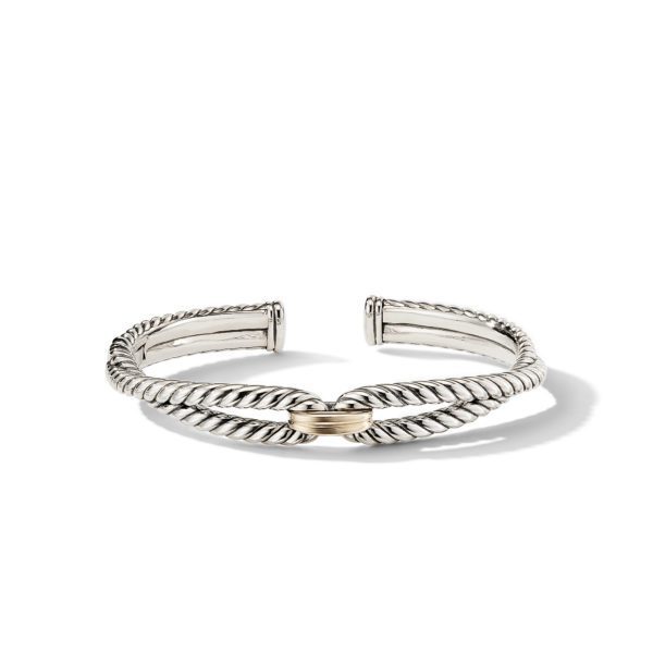 A silver cuff bracelet with a twisted rope design and an open end. The center of the bracelet features a gold accent, creating a contrast with the silver. The bracelet is displayed on a plain white background, casting a slight shadow.