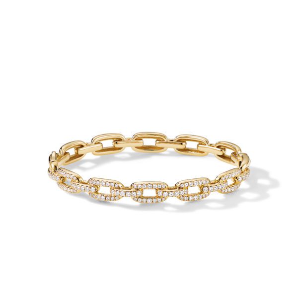 A gold bracelet with a chain link design, each link encrusted with sparkling diamonds. The bracelet is set against a white background, casting a slight shadow.