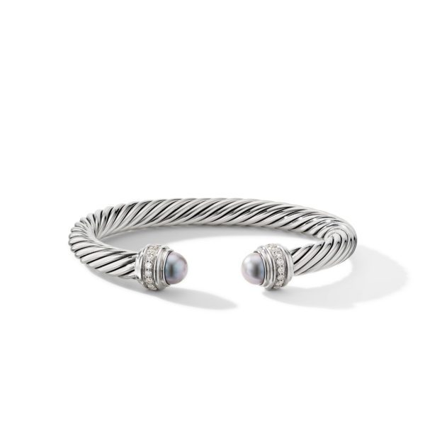 A twisted silver cuff bracelet with open ends, each adorned with a grey pearl and encrusted with small diamonds.