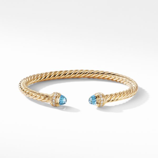 A gold twisted cable bracelet with open ends, each adorned with a round blue gemstone encircled by small gold bands. The bracelet has a sleek, polished finish and is showcased on a plain white background.