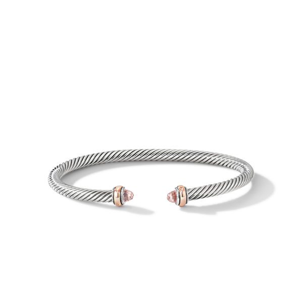 A silver twisted cable bracelet with open ends, featuring two rose gold caps adorned with pink gemstones. The design is both elegant and minimalistic, highlighting the contrast between the silver cable and the rose gold detailing.