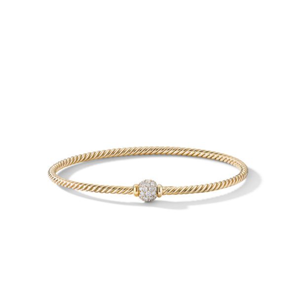 A delicate gold twisted cable bracelet is shown with a single round diamond-encrusted bead in the center. The bracelet casts a soft shadow against a plain white background.