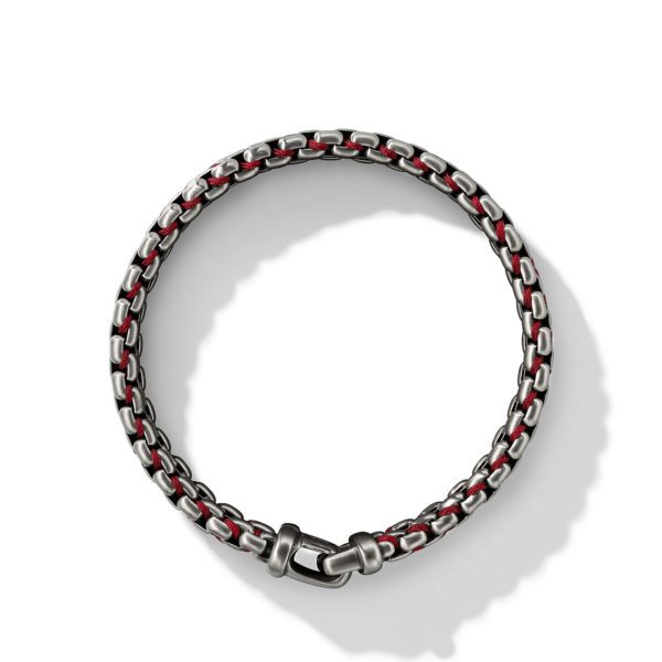 A stylish bracelet featuring interwoven silver and red links, creating a chain-like pattern. The bracelet has a sleek, polished finish and a secure clasp. The design casts a subtle shadow on a white background, emphasizing its texture and craftsmanship.