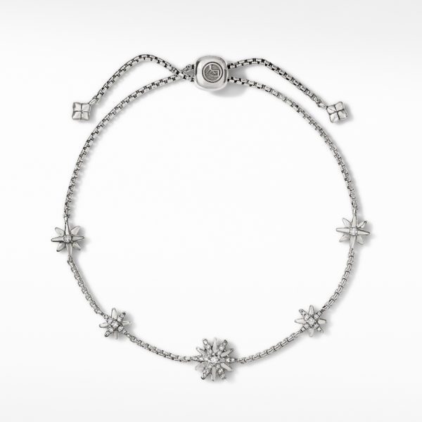 A delicate silver bracelet with an adjustable sliding clasp. It features evenly-spaced star-shaped charms, where some stars are filled with tiny crystals, and others are hollow. The bracelet exudes a blend of elegance and celestial charm.