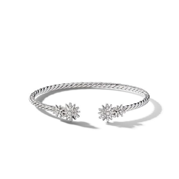 A silver twisted rope bracelet with an open-ended design featuring two starburst-shaped embellishments on each end, embedded with small sparkling stones, photographed against a plain white background.