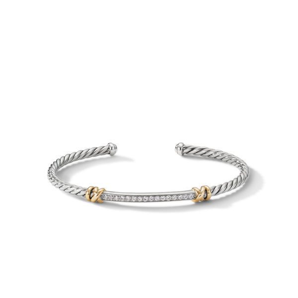 A silver rope-style bracelet with an open design and a bar covered in small diamonds at the center. The bar is accented with two small gold loops on each side. The bracelet has a sleek and elegant appearance.