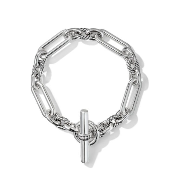 A silver chain bracelet featuring large interconnected rectangular links and a toggle clasp. The design includes some twisted elements, adding an intricate detail to the overall look. The bracelet is arranged in a circular shape on a white background.