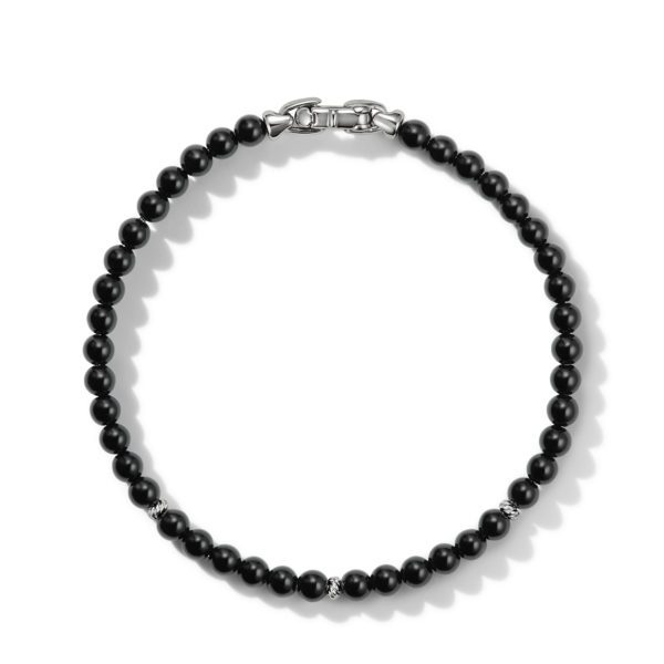 A black beaded necklace featuring round beads, with a few silver accents and a metallic clasp. The overall design is elegant and minimalist, suitable for both casual and formal wear.