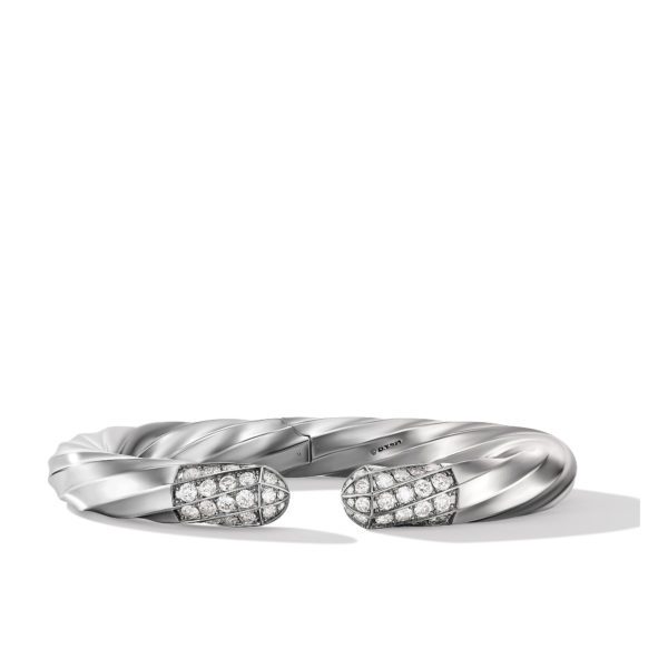 A sleek, silver twisted cuff bracelet with its open ends adorned in a cluster of sparkling diamonds, set against a clean white background.