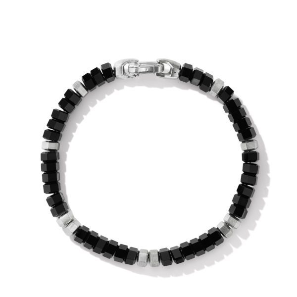 A close-up of a beaded bracelet featuring alternating black and metallic square beads, forming a circular pattern around the wrist. The bracelet has a metallic clasp at the top, completing the modern and sleek design. The background is white and plain.