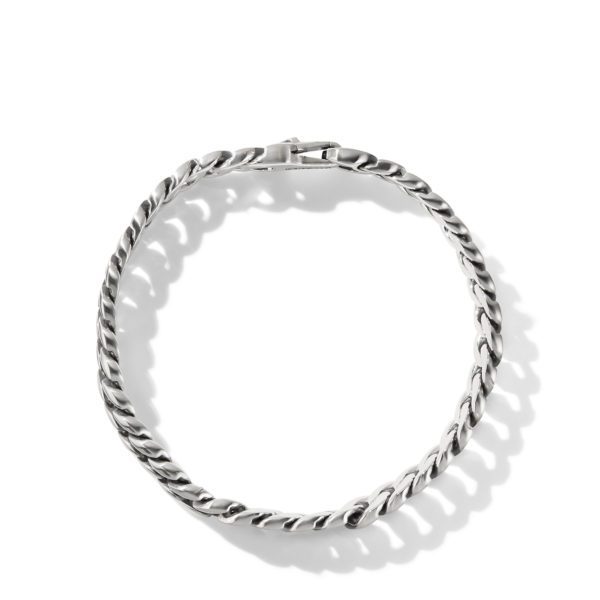 A silver twisted rope chain bracelet with a sleek clasp lies in a circular shape against a white background. Its polished metal surface reflects light, highlighting the interwoven design of the links.