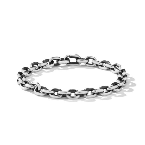 A close-up image of a silver chain bracelet with large, rounded links and a polished finish. The bracelet is arranged in a circular shape, showcasing its interlocking design, and casting a shadow on the plain white background.