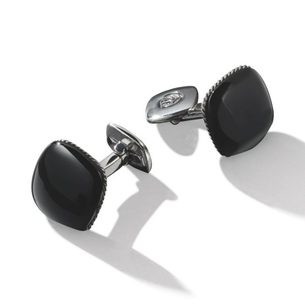 A pair of elegant cufflinks with square, glossy black faces set in silver-toned metal. The cufflinks are slightly tilted against a white background, casting soft shadows. The black faces have smooth, rounded edges with a subtle, textured border.