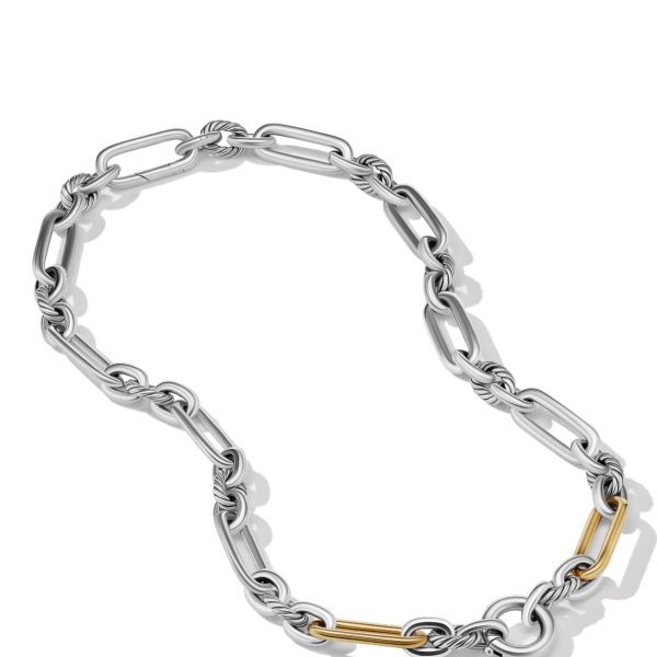 A close-up of a stylish chain necklace featuring silver elongated links intertwined with twisted designs. The necklace also contains a few yellow-gold links, creating a striking contrast. The background is plain white.