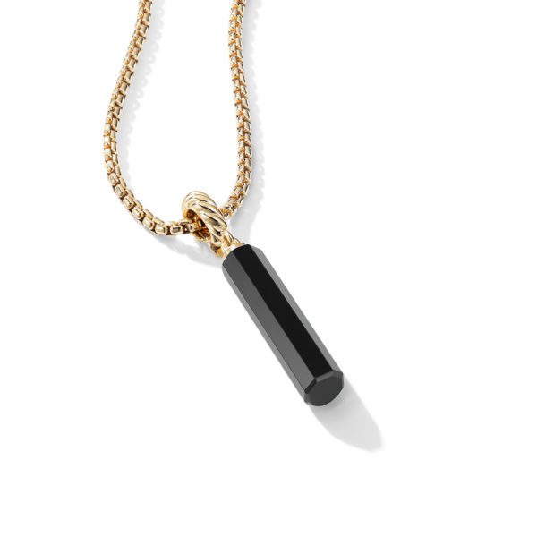 A gold chain necklace with a black hexagonal prism pendant. The pendant hangs from a detailed, gleaming gold bail. The background is white, making the necklace's gold and black colors stand out.