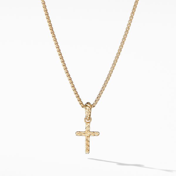 A gold chain necklace with a small, intricately detailed gold cross pendant hanging from it. The cross features a smooth and polished surface, and the chain has a delicate, linked design. The necklace is photographed against a plain, white background.