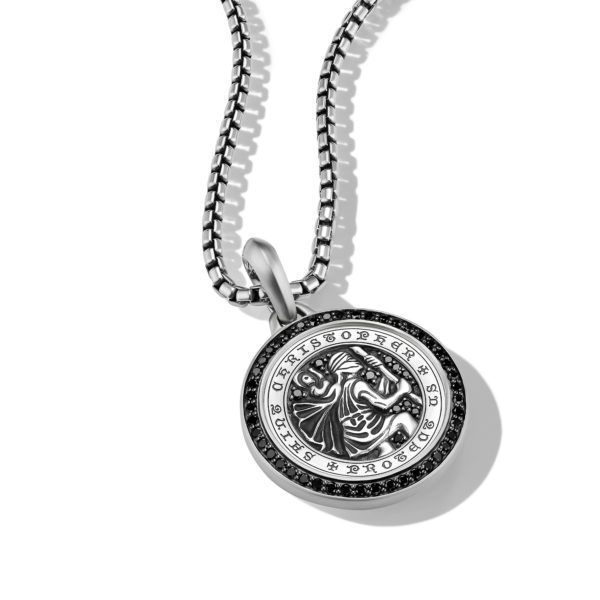 A silver pendant necklace featuring an intricate embossed design of a saint figure, with the text "Saint Christopher" engraved around the edge. The pendant hangs on a sturdy, polished chain, casting a shadow against a white background.