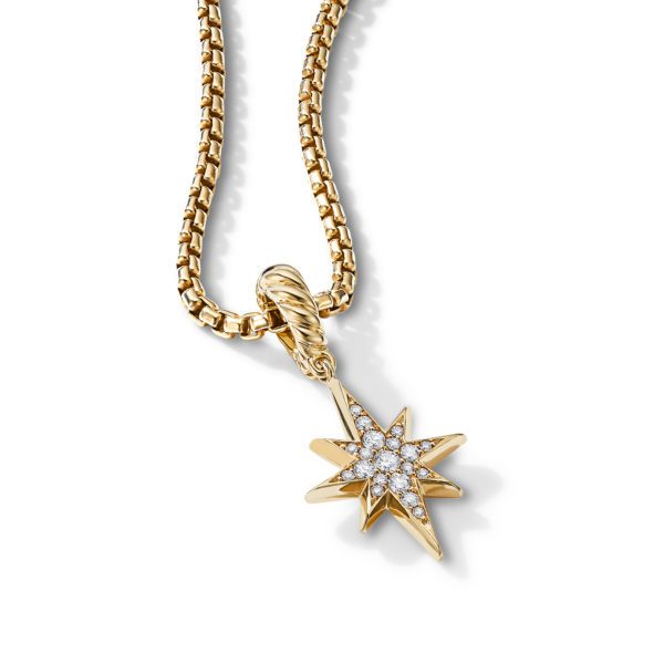 A gold necklace with a star-shaped pendant encrusted with small diamonds. The pendant features multiple pointed rays and is attached to the gold chain by a twisted loop. The background is plain white, highlighting the jewelry.