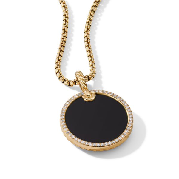 A round black pendant encased in a gold frame adorned with small diamonds, hanging from a textured gold chain. The pendant's surface is smooth and reflective, and the jewelry piece has a luxurious, elegant appearance.