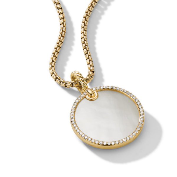 A gold chain necklace features a round pendant with a mother-of-pearl inlay, surrounded by a border of small, sparkling diamonds. The pendant and the chain both have a lustrous finish, and the jewelry is displayed against a white background.