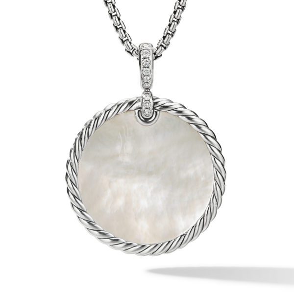 A silver necklace features an oval pendant with a mother-of-pearl center. The pendant is framed with a twisted rope design and has small, embedded gemstones at the top where the pendant attaches to the chain. The necklace is displayed against a white background.