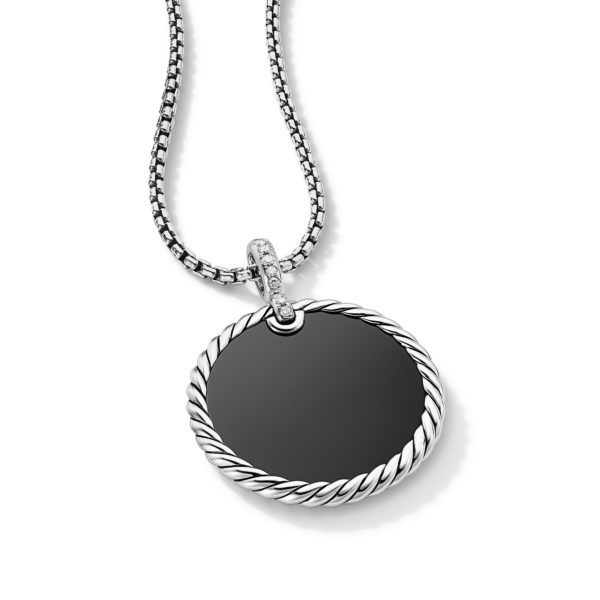 A silver necklace with a round pendant featuring a smooth, black center, bordered by a twisted silver rope design. The pendant is attached to a sleek silver chain with a small, embellished loop. The necklace is displayed against a plain white background.