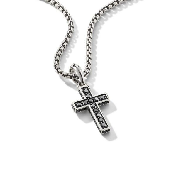 A silver cross necklace with black gemstones embedded in the cross pendant, hanging from a silver chain with a box link design. The cross pendant has a slightly raised edge, giving it a three-dimensional look, and is set on a white background.