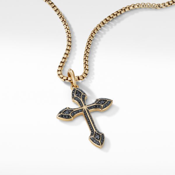 Gold chain necklace with a pendant in the shape of a cross. The cross is bordered in gold with a textured black interior adorned with small, glittering stones. The image has a clean, white background.