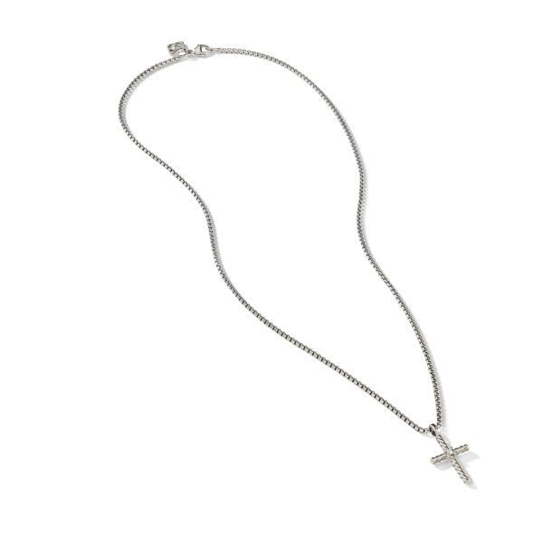 An elegant silver necklace featuring a simple metal chain and a pendant shaped like a cross with small embedded stones. The necklace is displayed on a white background.