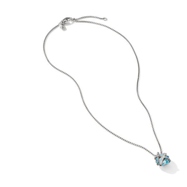 A delicate silver necklace with a thin chain and an adjustable clasp. The pendant features a blue heart-shaped gemstone encased in a silver design entwined with small clear stones, adding an elegant and sparkling touch.