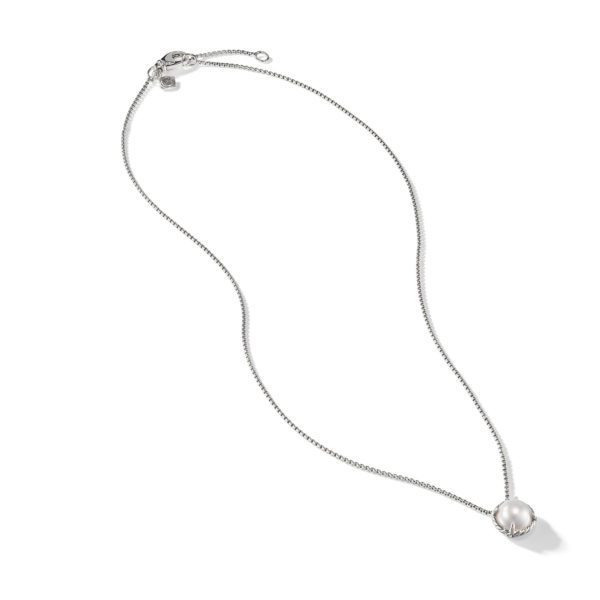 A delicate silver necklace featuring a single round pearl pendant. The chain is slender and has a clasp at one end. The pearl pendant is held in place with a simple and elegant setting, giving the necklace a refined and classic appearance.