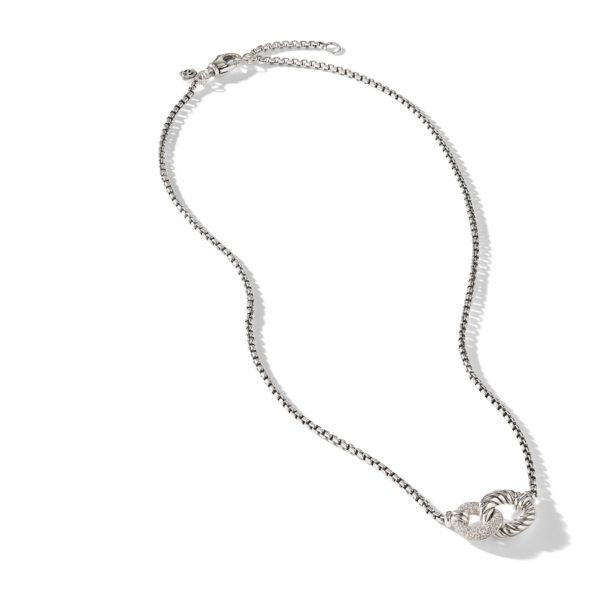 A delicate silver chain necklace features a heart-shaped pendant with an intricate design. The chain is dainty and elegant, and the pendant adds a touch of sophistication. The image is set against a plain white background.