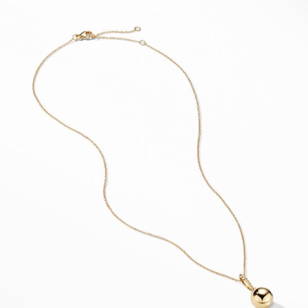 A delicate gold chain necklace with a polished gold spherical pendant resting at the center is displayed on a white background. The necklace is laid out in a simple, elegant curve, with the clasp visible at the top end.