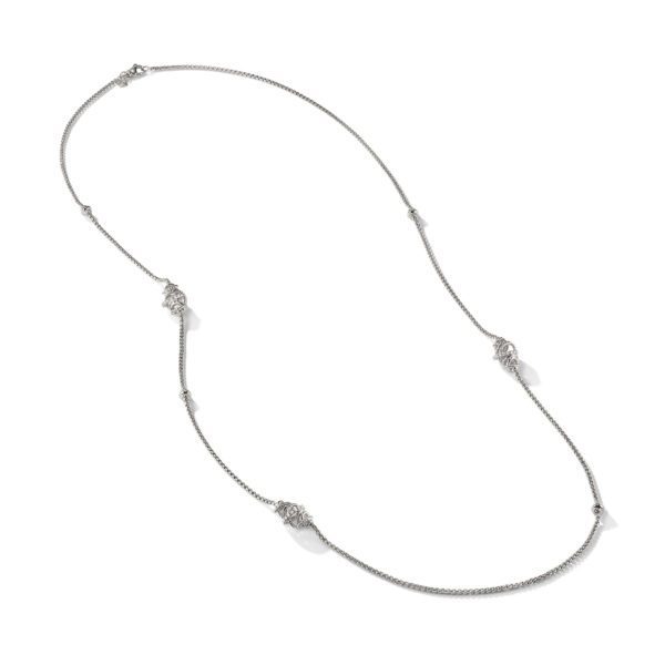 A delicate silver long chain necklace featuring evenly spaced, intricately designed floral motifs. The necklace has a simple and elegant appearance, suitable for a variety of occasions.