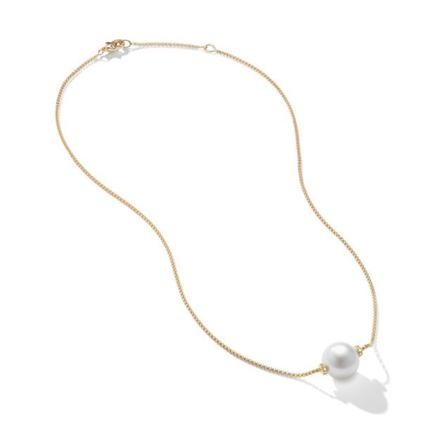 A delicate gold chain necklace featuring a single, large white pearl centerpiece. The necklace is laid flat against a white background, highlighting its simplicity and elegance.