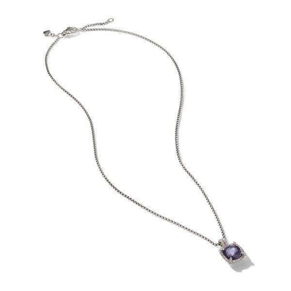 A silver necklace featuring a thin chain with a small square pendant. The pendant contains a purple gemstone surrounded by tiny clear stones. The necklace is displayed against a plain white background.